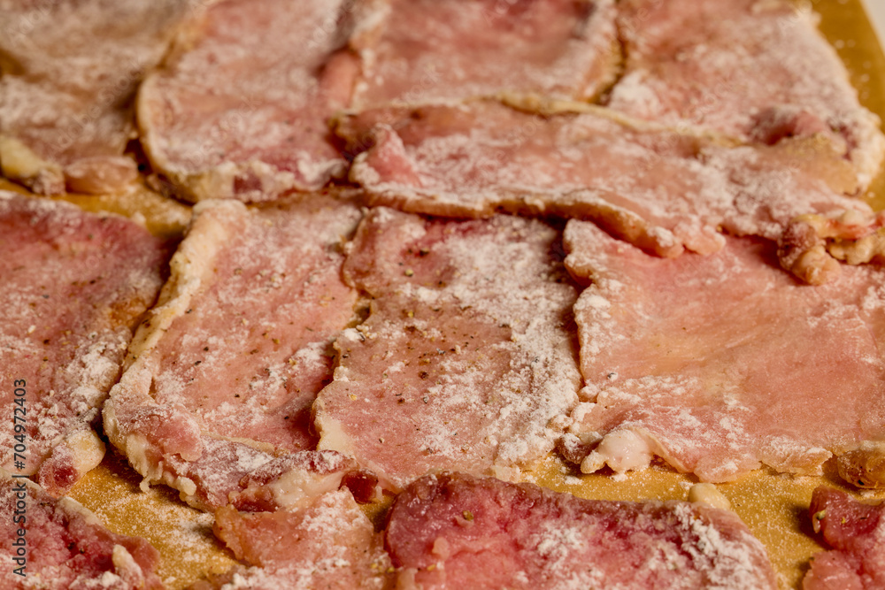 Pork tenderloin thinly sliced and prepared for schnitzel before cooking.