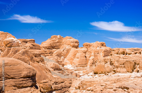 peaks of high stone rocks against a blue sky in Egypt Dahab South Sinai