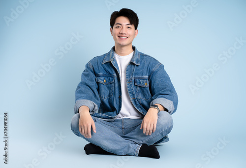 Full body image of Asian guy posing on blue background