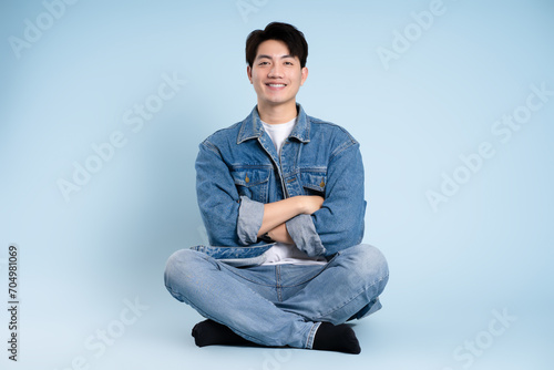 Full body image of Asian guy posing on blue background