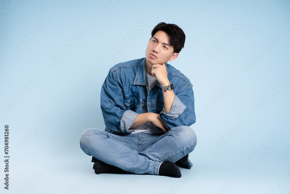 Full body image of Asian guy posing on blue background Full body image of Asian guy posing on blue background
