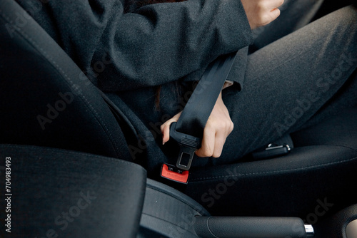 Woman hand fastens the seat belt of the car. Close your car seat belt. Closeup shot of female driver fastens seat belt