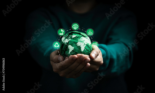 Businessman holding green scrap paper ball with world map and environment icon such as carbon reduction green factory recycle and solar cell for zero carbon emission credit to prevent global warming.