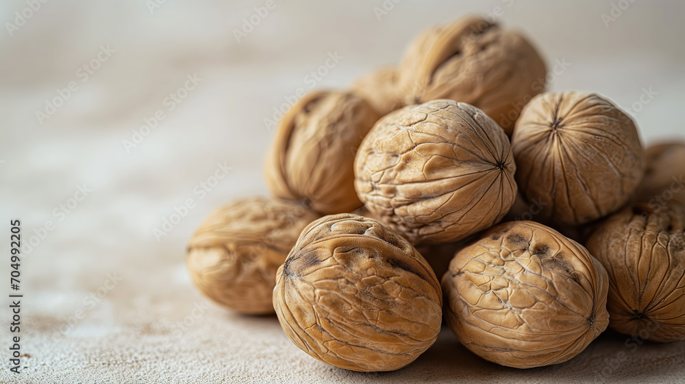 Heap of whole walnuts on a beige surface. Heap of whole walnuts on a beige surface.