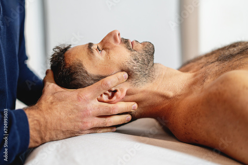 Gentle craniosacral therapy performed by an osteopath, targeting neck pain. photo