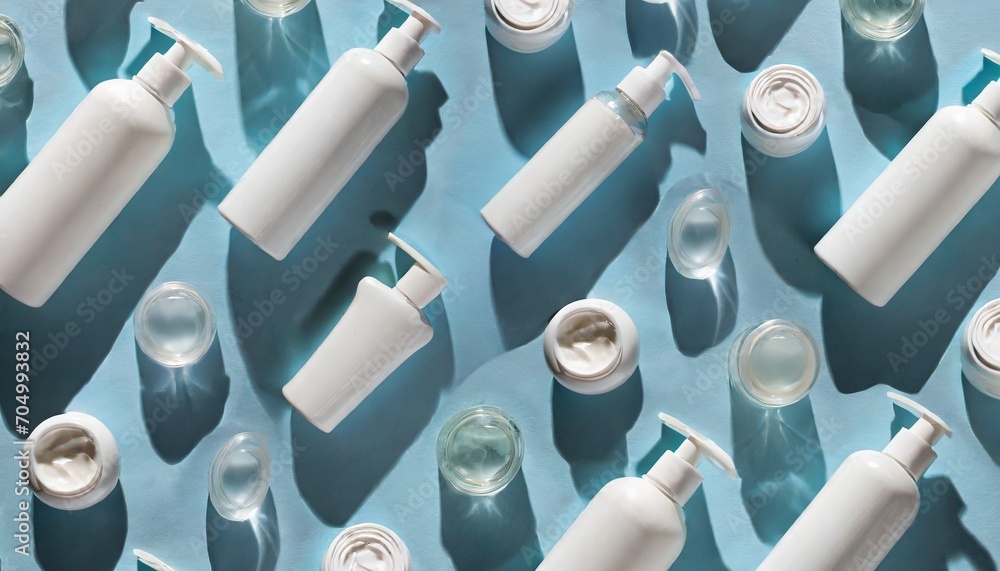Creative layout featuring a pattern of white bottles and jars of cosmetic products casting strong shadows on a vibrant blue background. Ideal as a backdrop or texture for your design. - obrazy, fototapety, plakaty 