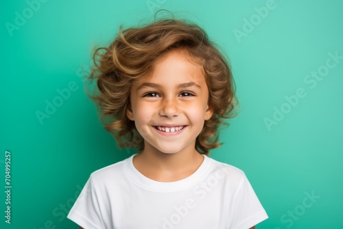 Portrait of a smiling little girl on a turquoise background
