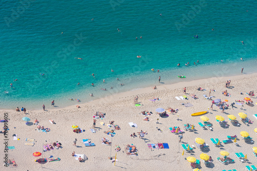 Beautiful top view of blue sea ocean water and beach shore with lots many of people tourists in summertime and bright sunlight sun.Tourism destination,vacation,holiday