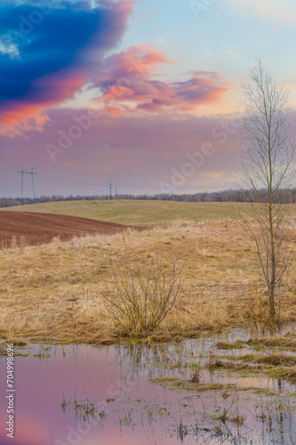 Witness the stunning play of colors at sunset over a plowed field. Enjoy a masterpiece of nature while admiring the breathtaking sunset views. scenic background