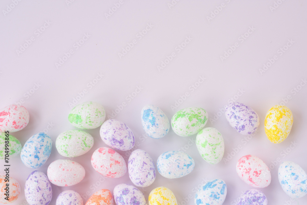 Background with copy space pattern with multi colored easter eggs in yellow, pink, green, blue colors.