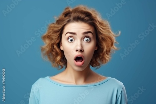 Why is that. Beautiful female half-length portrait isolated on trendy blue studio background. Young emotional surprised, frustrated and bewildered teen girl. Human emotions © Areesha