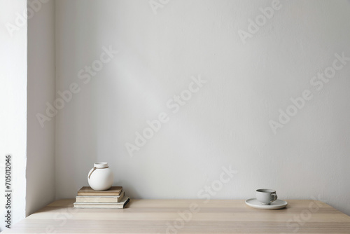 Modern interior, japandi home design. White vase, cup of coffee and old books on wooden table. Beige wall mockup background. Elegant living room, home office. No people. Trendy indoor still life.