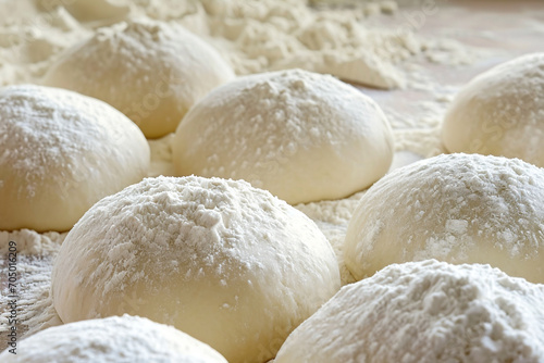 Closeup of flour covered several white dough balls on a wooden table with dough powder.Food Industrial,Food Manufacturing Concept.Food Recipes Concept.