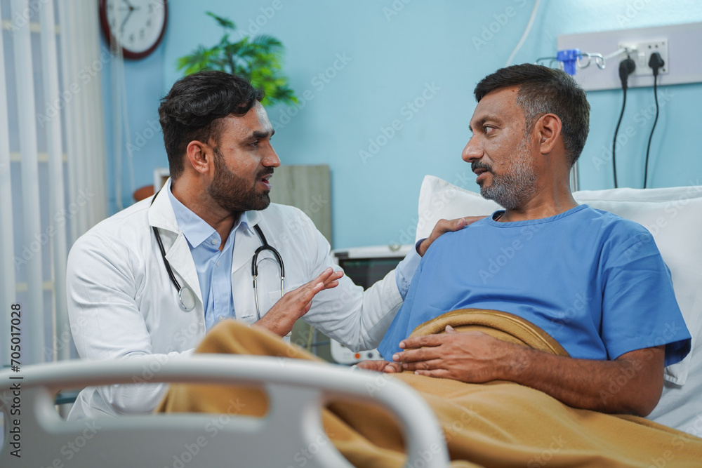 Obraz premium Indian doctor consoling sick elderly patient at hospital ward during routine visit - concept of medical treatment, building confidence and motivation