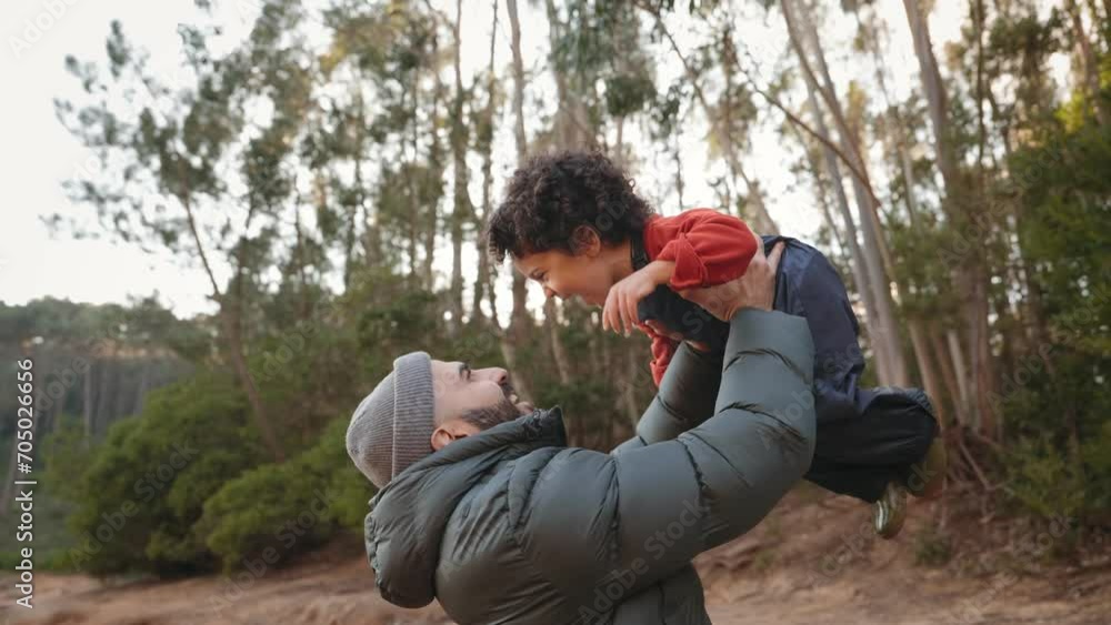 A heartening moment captured as a young father lifts his delightful little boy into the air during a walk in the forest. Pure joy and shared happiness. A heartening moment captured as a young father lifts his delightful little boy into the air during a walk in the forest. Pure joy and shared happiness.