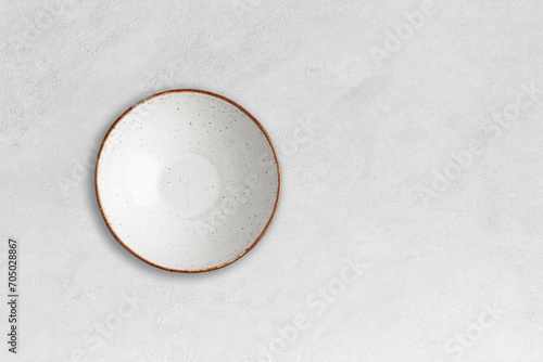 Handmade empty ceramic plate top view with copy space on grey concrete table. Minimalism. Eco friendly ceramics handcraft tableware.