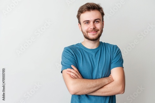 Man With Arms Crossed Standing in Front of White Wall