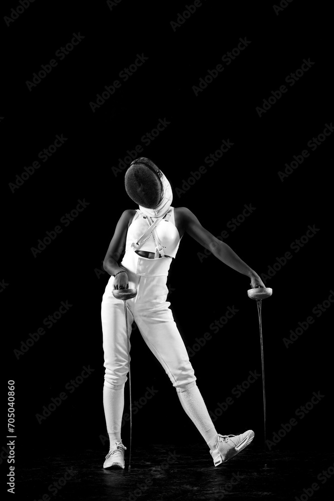 Fencing maestro, delicately leaning on fencing foil, radiating confidence and poise against black studio background. Blend of strength and grace. Concept of professional sport, championship. Ad