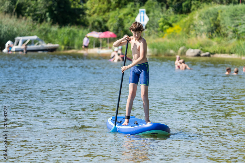 Teenager and SUP board. Active recreation on the Senftenberg lake. Federal land of Brandenburg. Germany.