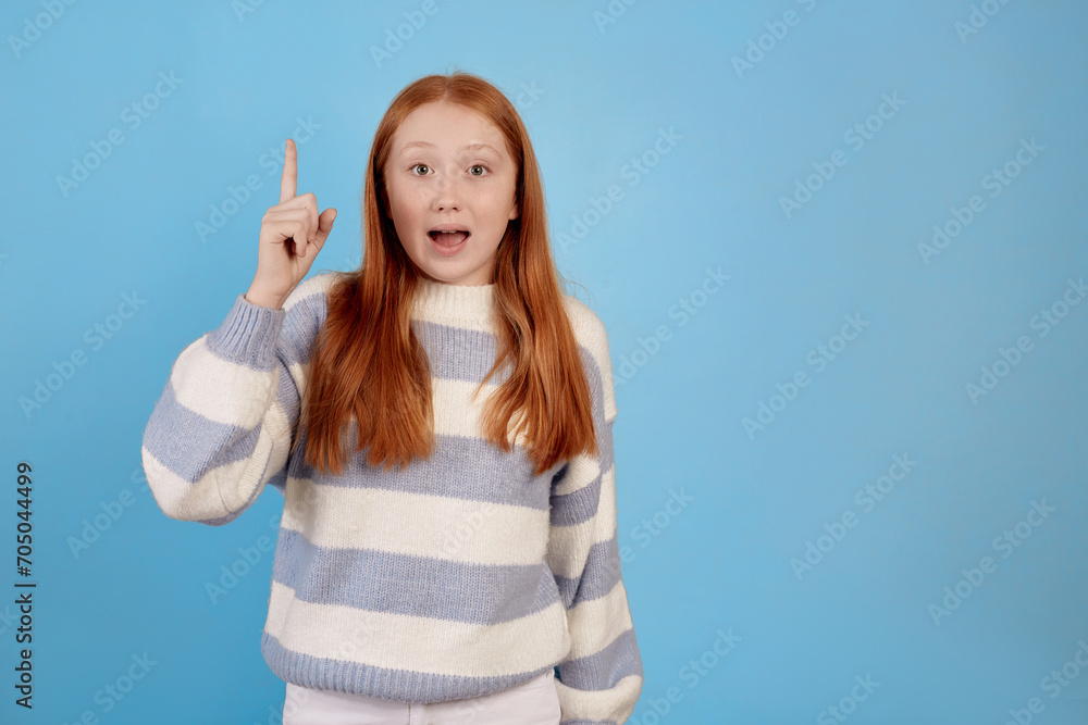 Surprised redhead teenage girl on blue background in studio. Surprised redhead teenage girl on blue background in studio.