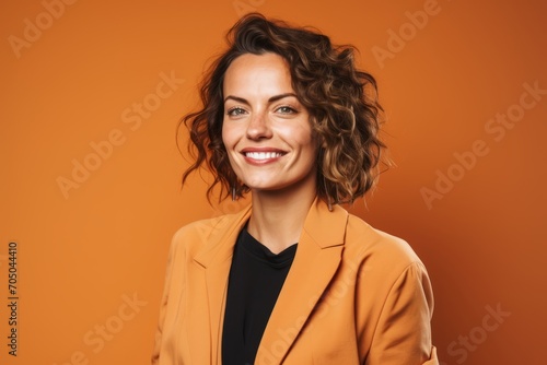 Portrait of a beautiful woman with curly hair on orange background. © Loli
