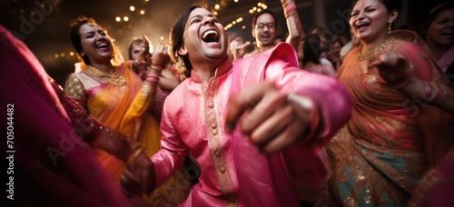 Joyful wedding guests dancing at traditional Indian ceremony. Cultural celebration. photo