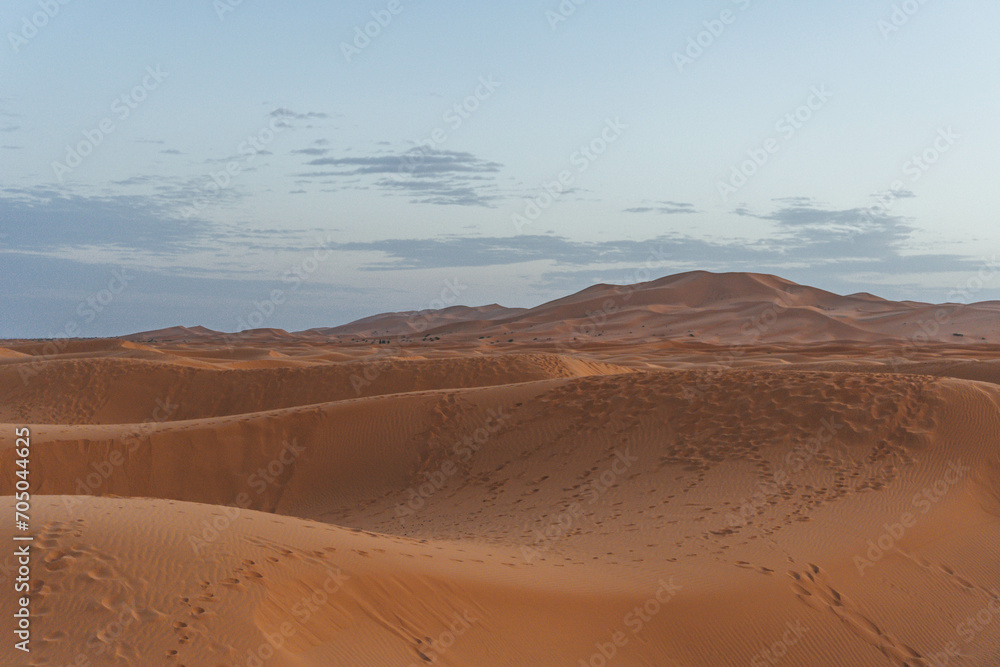 minimalist look of big sand dunes in the desert morocco with orange color view at sunset time