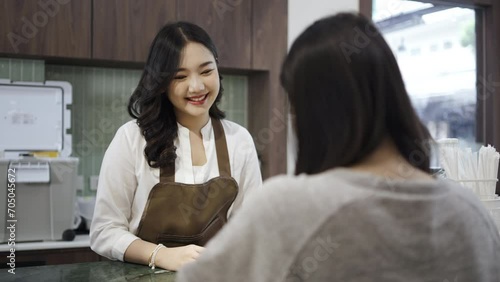 Young asian beautiful female customer select coffee or juice items. with a young woman barista working at the cafe or restaurants counter, entrepreneurial concept Starting a small business, lifestyle photo