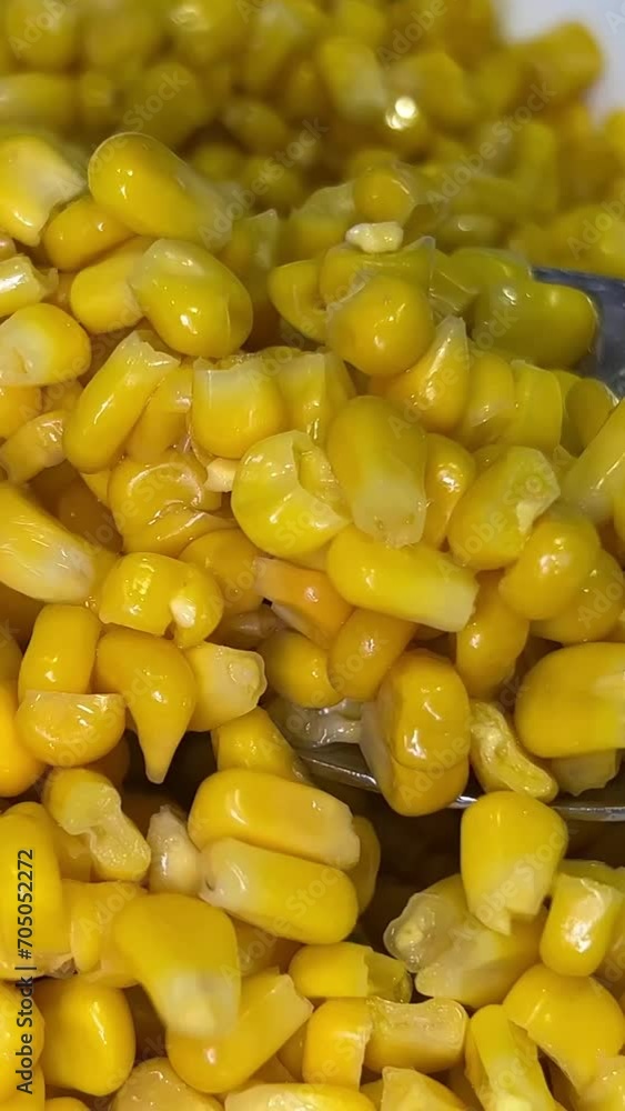 Spoon holding marinated sweet yellow corn seeds in metal can container close up. High quality 4k footage Spoon holding marinated sweet yellow corn seeds in metal can container close up. High quality 4k footage