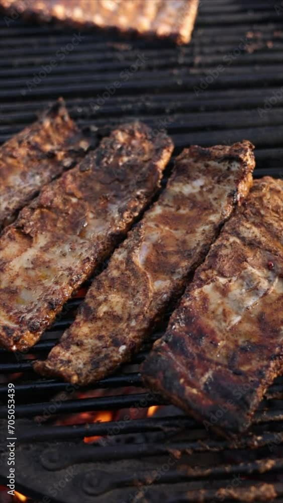 The chef cooks delicious ribs on the grill. Close-up The chef cooks delicious ribs on the grill. Close-up
