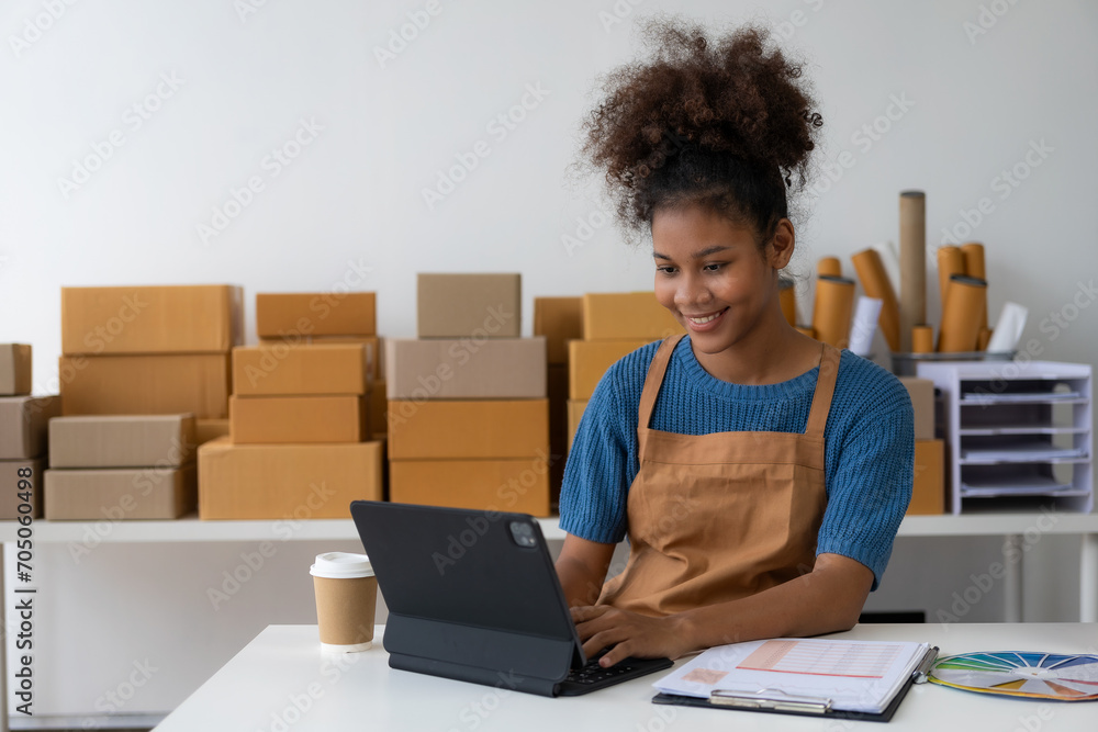 Black female designer, computer work, tailoring, fashion, small business Creative business African American entrepreneur girl smiles and checks online orders. Successful SME business idea. Black female designer, computer work, tailoring, fashion, small business Creative business African American entrepreneur girl smiles and checks online orders. Successful SME business idea.