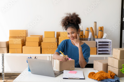 Black female designer, computer work, tailoring, fashion, small business Creative business African American entrepreneur girl smiles and checks online orders. Successful SME business idea.