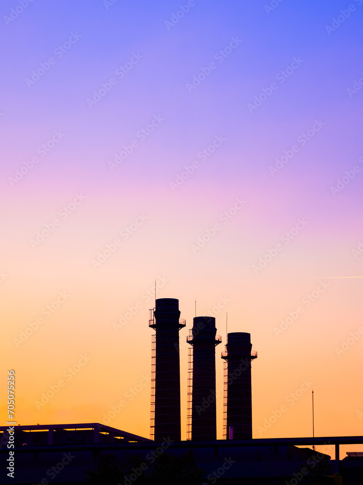 Three industrial factory chimneys at sunset in Barcelona, Spain