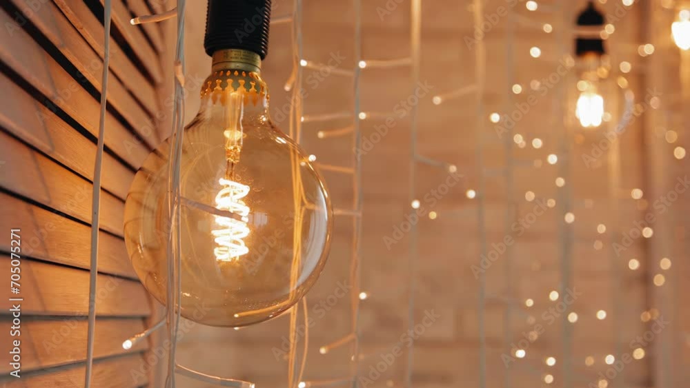 A close-up of a large lamp that decorates the room and illuminates it with warm light. Very beautiful color A close-up of a large lamp that decorates the room and illuminates it with warm light. Very beautiful color