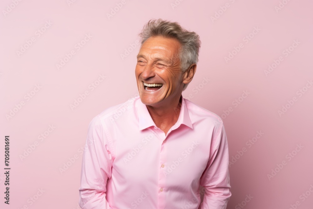 Portrait of happy senior man laughing and looking at camera on pink background Portrait of happy senior man laughing and looking at camera on pink background