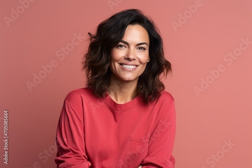 Portrait of a beautiful woman smiling at the camera on a pink background