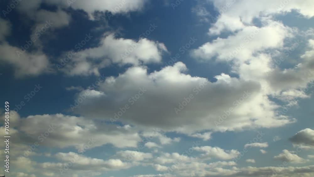 Clouds move swiftly across blue sky in timelapse. Dynamic weather change over cityscape. Skyscape speeds through day. Fast-moving cumulus, potential for natural, eco, weather, climate projects. Clouds move swiftly across blue sky in timelapse. Dynamic weather change over cityscape. Skyscape speeds through day. Fast-moving cumulus, potential for natural, eco, weather, climate projects.