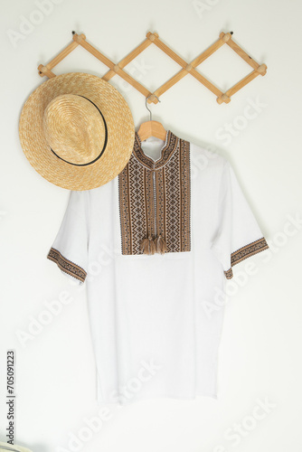 Ukrainian clothes embroidered shirt. Brown beige and white black threads background. Vyshyvanka symbol of Ukraine. Embroidery cross stitching. National Ukrainian stitch. Traditional clothing Straw hat