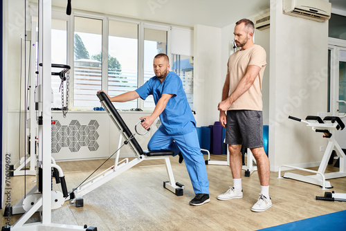 skilled instructor in blue uniform showing how to train on exercise machine in kinesiology center