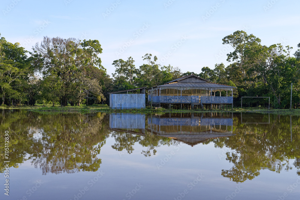 Fototapeta premium Wooden houses on stilts reflecting in the Amazon River, Amazonas state, Brazil