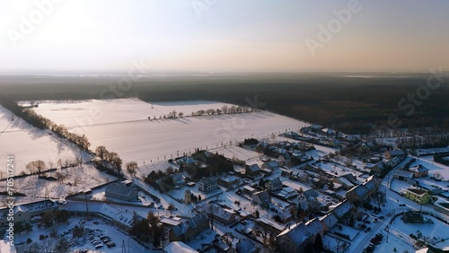 Widok miejscowości Dąbrowa przed zachodem słońca pola i zabudowania. photo