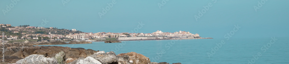 Panoramic view of a beautiful town on the hills leading to the coast, comfortable beaches and azure sea in Calabria, Italy Panoramic view of a beautiful town on the hills leading to the coast, comfortable beaches and azure sea in Calabria, Italy