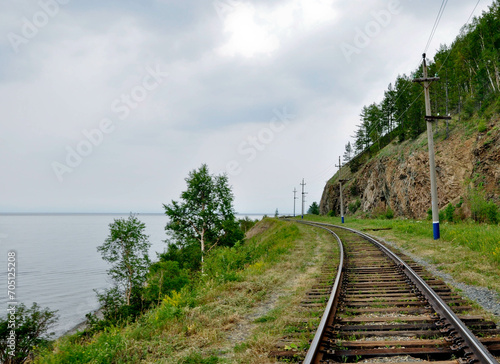 Jezioro Bajkał, Rosja. Brzeg jeziora z kamienistą plażą, tory kolejowe, łodzie, pomosty w wodzie.