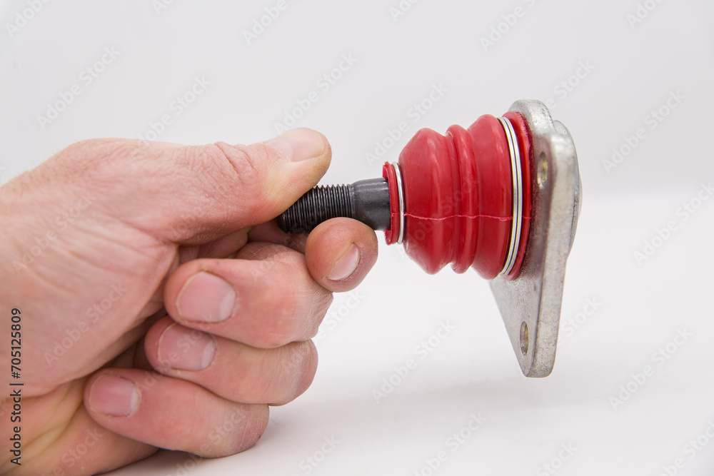 Close-up. Shallow depth of field. Selective focus. A man's hand holds a ball joint of a car on a white background. Close-up. Shallow depth of field. Selective focus. A man's hand holds a ball joint of a car on a white background.