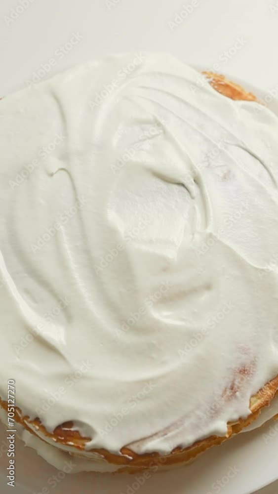 A confectioner prepares a cream cake. Dessert on a white table in the kitchen. The concept of home baking, cooking cakes. High quality footage A confectioner prepares a cream cake. Dessert on a white table in the kitchen. The concept of home baking, cooking cakes. High quality footage