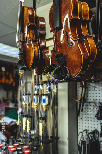 there are many violins hanging from the ceiling at a store