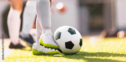 Soccer Ball in Motion Kicked by a Soccer Player. European Football Horizontal Background. Player in white soccer cleats and soccer socks. Moment of football ball kick © matimix
