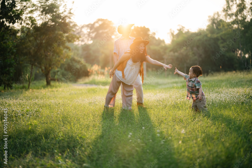 Fototapeta premium happy harmonious family outdoors concept father and mother and son have activities together on holidays, nature grassland field