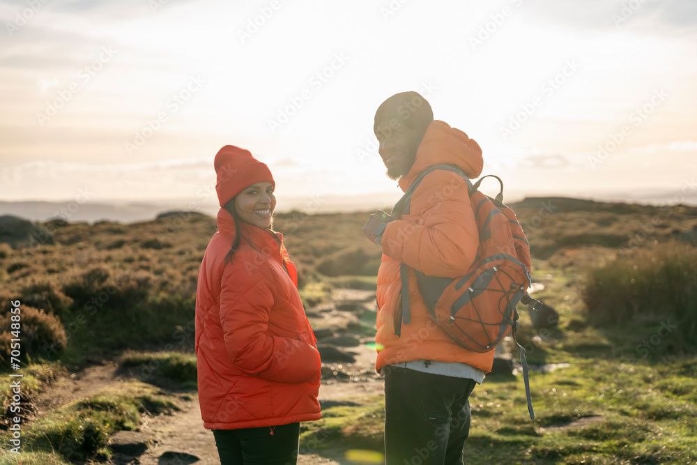 Portrait of happy couple in love walking along countryside at the sunset.  Love, hiking and active lifestyle concept
