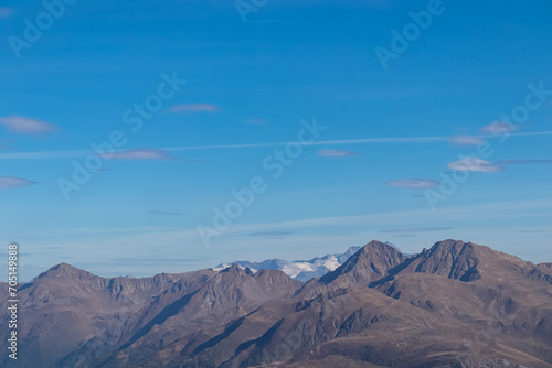 Scenic view of majestic mountain peaks of untamed High Tauern, Austria Italy border, Europe. Hiking concept Italian Alps. Blue clear sky. Looking from summit Hornischegg in South Tyrol, Carnic Alps